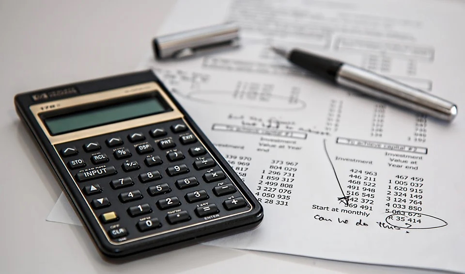 A calculator and finance sheet laid out on a table